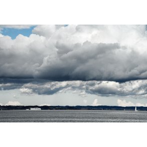 Molslinien sejler hurtig forbi Mols med tunge regnvejsskyer over sig