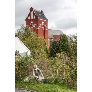 Smuk person skulptur ved indk�rsen tii �lum, med �lum kirke i baggrunden