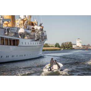 Kong Frederik d. X'ende hilser p� broen af Dannebrog p� vej ind i Randers havn