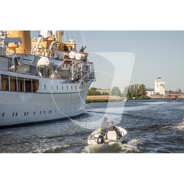 Kong Frederik d. X'ende hilser p� broen af Dannebrog p� vej ind i Randers havn