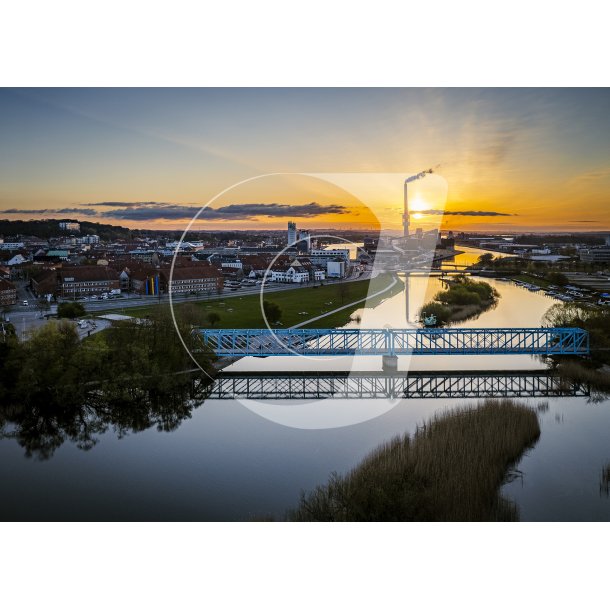 Dronefoto af solopgang over Randers, med Verdo, Randers Havn, Gudenen og Den Bl Bro